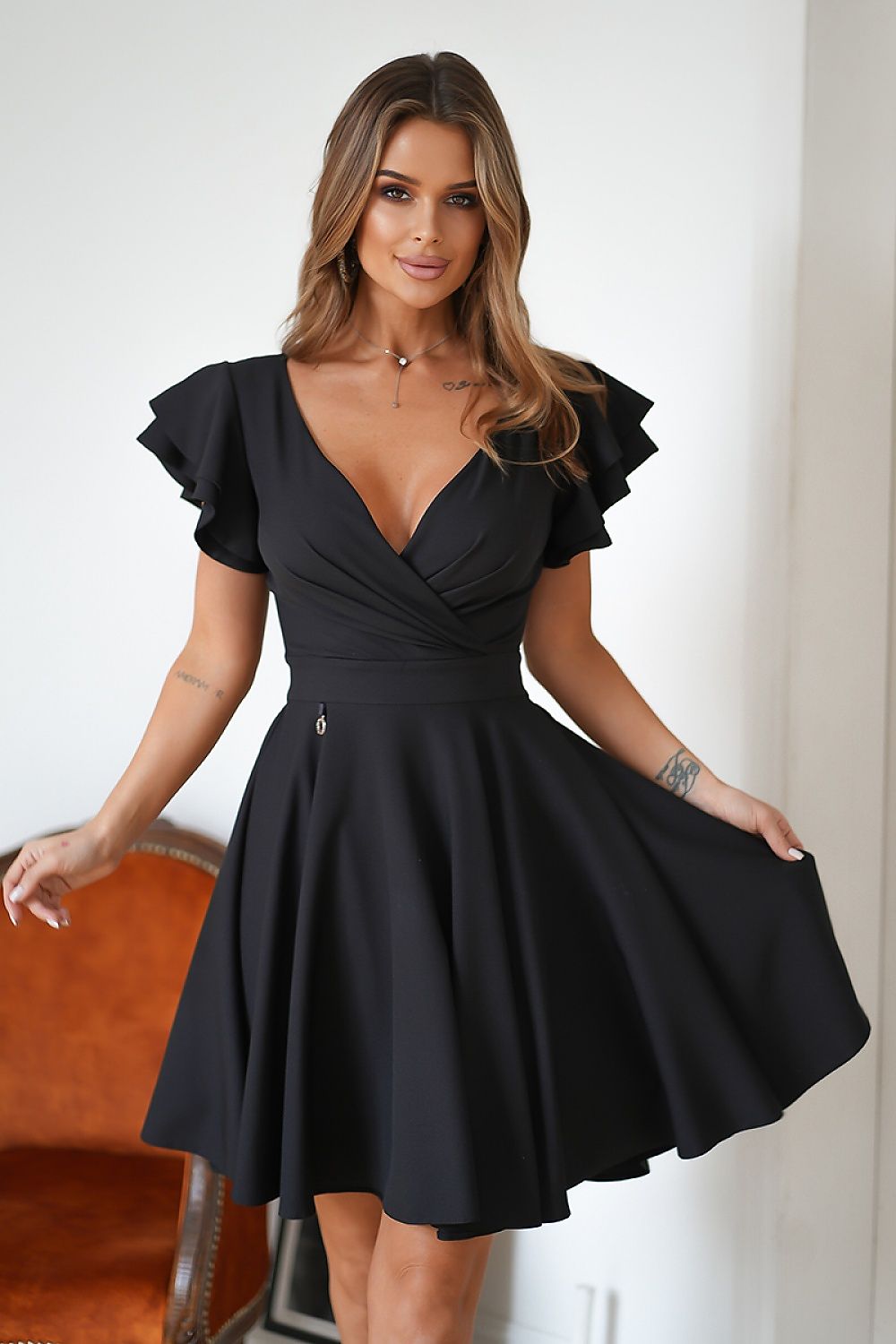 Vrouw in Ruffle Charm taillejurk met ruches aan de mouwen – elegante meisjesachtige jurk