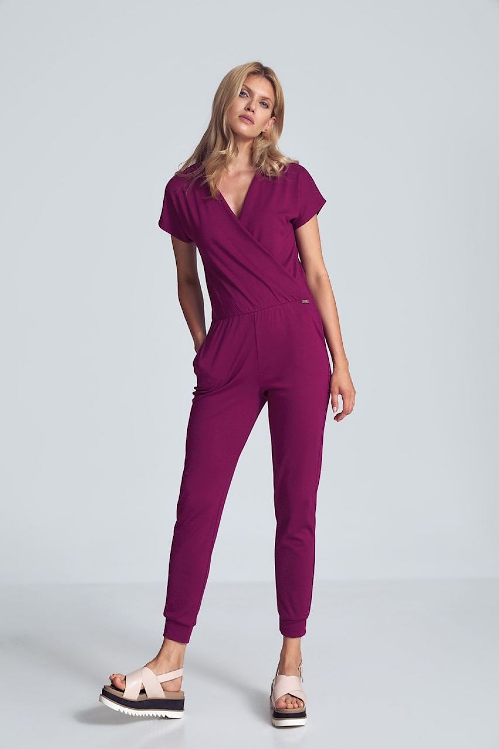 Paars jumpsuit met crinkle halslijn, elastische taille en taps toelopende pijpen met drawstring.